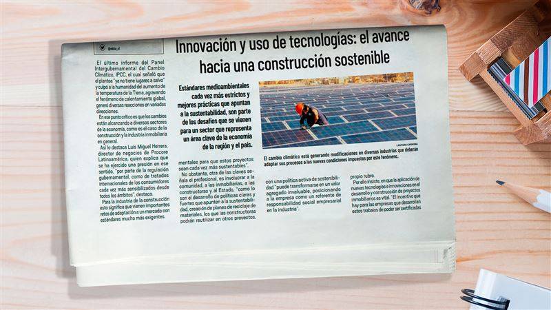 Diario en mesa con noticia de construcción sostenible